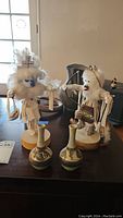 Two Native American Kachina dolls and two small Japanese vases displayed on a table
