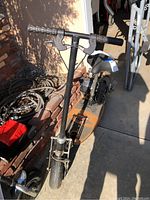 Front view showing handlebar grips, brake and throttle levers, front tire and deck.