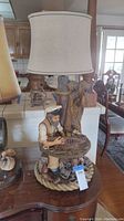 Full view of nautical table lamp showing sailor figure, lamp shade, and base details.