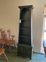 Front view of vintage pyramid bookshelf showing three shelves and lower cabinet with two doors.