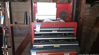 full view of red Craftsman tool chest with top lid open, showing overall condition and contents