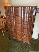 Front view of the vintage French Provincial 5 drawer chest of drawers showing scalloped front and brass handles