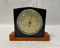 Front view of a 1940s Taylor Bakelite Baroguide barometer with a convex glass dial showing weather and barometric pressure indicators.