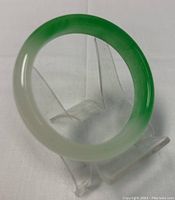 Top view of the jade bangle showcasing the smooth finish and color gradient from white to green.