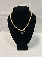 Front view of the faux pearl necklace with heart pendant displayed on a black bust.