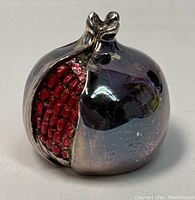 Front view of 925 silver pomegranate paperweight showing red enamel seed detail on an open segment.