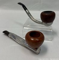 Two vintage tobacco pipes, Spiral Cool and Falcon, side by side on display.