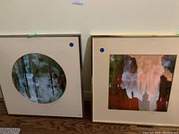 Two framed enamel art pieces by A Alan Perkins, showing abstract color drip designs and textures, size 18x18 inches each.