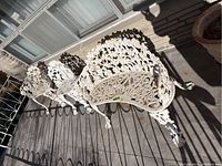 Overview of one bench and two chairs on tiled patio in sunlight