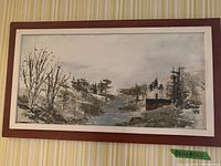 Framed landscape painting showing a New Brunswick scene with a river, leafless trees, and forested background in muted tones.