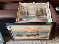 Overview of both framed paintings stacked on sofa