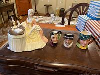 Overview of Royal Doulton figurine and three mini character jugs