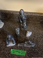 Overview photo showing all five soapstone carvings arranged on a granite surface, displaying different sizes and shapes.