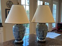Pair of lamps on granite countertop in front of patio doors