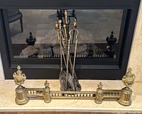 Front view of brass fireplace fender and tool set on hearth