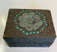 Front view of the lid showing carved jade medallion and surrounding turquoise cabochons