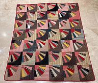 Full view of entire quilt laid flat on floor showing 35 fan blocks