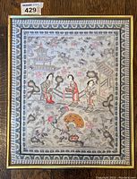 Full view of framed tapestry showing entire embroidered design and frame