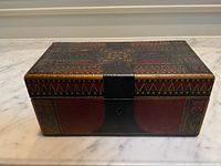 Front and top view of closed tea caddy showing painted exterior and lockable front