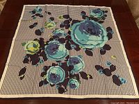 Full view of the scarf showing the floral pattern on houndstooth background and the overall size and shape.