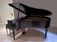 Side profile of baby grand piano with lid open