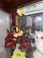 Photo showing red, black, and creamy white elephant figurines with some reflections and lighting effects.