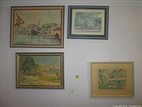 Four framed art prints on a wall, showing maritime and vintage scenes, including a ship, a rural landscape, and two architectural street scenes.
