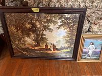 Large framed painting of figures walking through trees, showing detail and frame condition