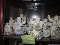 Front view of eight angel figurines lined up on a shelf, showing details of colors and designs