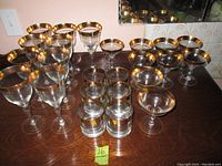 Various glassware pieces with gold trim, arranged on wooden surface