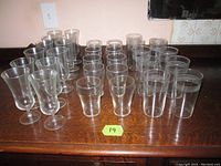 Top down view showing entire collection of glassware on a wooden surface with green lot number 19
