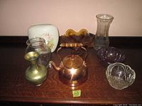 Photo of copper kettle, brass vase, various glass bowls, white ceramic vase with bird and floral design