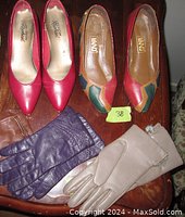 Top view of two pairs of women's shoes and three pairs of leather gloves on a wooden surface. Shoes include colorful patterned pair and red pair. Gloves are brown, purple, and beige with fur trim.