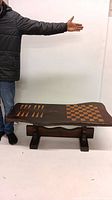 Full view of the coffee table with the built-in chess and backgammon boards shown on tabletop, highlighting its shape and wooden craftsmanship.