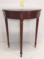 Front-facing full view of the half-circle Bombay Company side table showing the curved front and three legs.