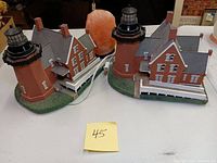 Two Block Island lighthouse light-up lamps and one Himalayan salt lamp shown on table with numbered label '45'.