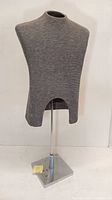 Front view of men's dress form torso covered in gray fabric on metal stand