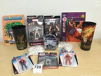 Full lot overview showing Marvel and Star Wars action figures in packaging, collectible glasses, coloring book, earbuds, and comic book
