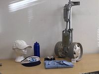 Full lot with golf pull cart, shirt, water bottle, sunglasses, baseball hat, visor, and golf balls on display