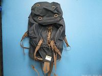 Front view of Tor65L hiking backpack showing main compartment, top flap, and brown straps.