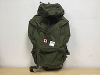 Front view of large olive green hiking backpack with flap pocket and bungee cord on top.