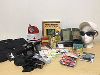 Wide shot of all items including clothing, stationery, books, and accessories laid on a white surface against a white wall.