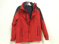 Front view of red women's coat with multiple zippered pockets and hood.