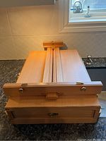 Folded front view of the beechwood easel with lock and storage box clasp visible.