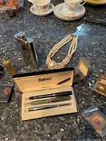 Stainless steel hip flask, faux pearl necklace, Fisher pen set, velvet boxes