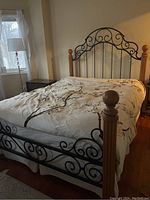 Assembled bed frame with headboard, footboard and rails shown in bedroom with bedding