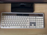 Top view of Logitech K750 wireless solar keyboard with Mac layout on a wooden surface.
