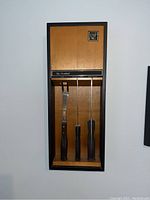 Photo showing wall-mounted 3-piece carving set with wooden handles and plaque labeled 'Eko Arrowhead'