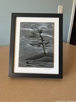 Front view of the glass etching artwork by Lee Sheldon in black frame on tabletop.