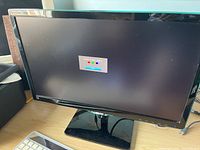 Front view of the Samsung 22 inch monitor powered on, showing a screen test pattern with color bars.